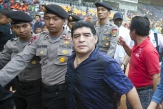 Legenda sepak bola dunia asal Argentina, Diego Armando Maradona, berjalan meninggalkan Stadion Gelora Bung Karno, Senayan, Jakarta, Sabtu (29/6)