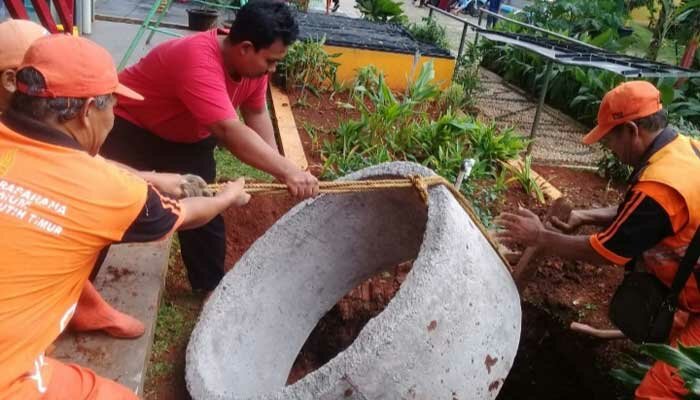 Petugas PPSU Kelurahan Cempaka Putih Timur tengah membangun sumur resapan. (ist)