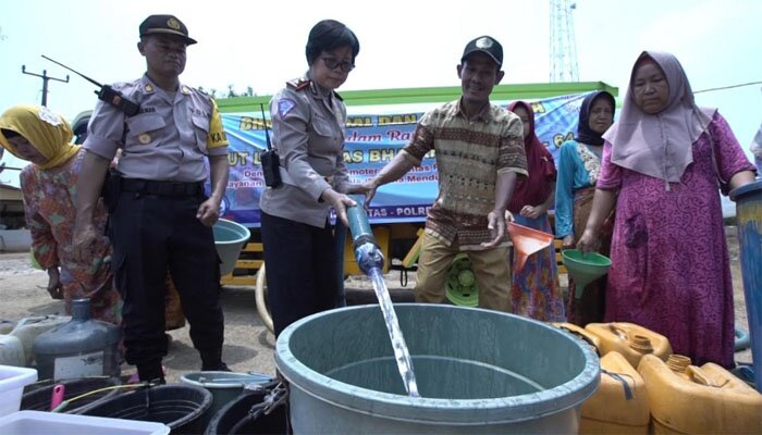 Wakil Kepala Satuan Lalu Lintas Polres Metro Bekasi, Kompol Sri Supadmi, bagikan air bersih ke warga yang kekeringan di Cibarusah. (ist)