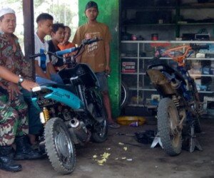 H Cadi pemilik bengkel sedang berbincang dengan Serda Eddy Widodo mengenai kian meningkatnya omzet pasca jalan didesanya leucir usai pelaksanaan TMMD ke 106.(dadan)