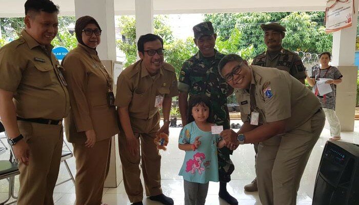 Lurah Tanah Tinggi, Imran disaksikan Kasatpel Dukcapil Kelurahan Tanah Tinggi, Imron Sumadi dan pejabat lainnya tengah menyerahkan KIA kepada seorang anak. (ist)