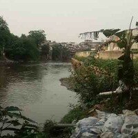 Hengki salah seorang warga yang menujukkan tembok dibibir kali Bukit Duri yang telah miring. (wandi)