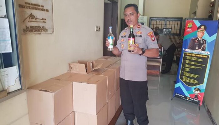 Kapolsek Sawangan Kompol Suprasetyo menyita ratusan botol di dalam 20 dus miras hasil operasi Cipkon. (angga)