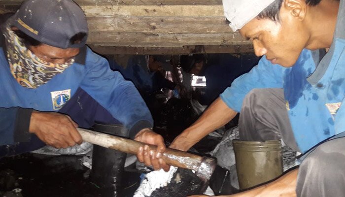 Pasukan biru Satpel SDA Kecamatan Kembangan menguras saluran tertutup dengan ketebalan lumpur 40 cm di saluran Phb Taman Kota di Kelurahan Kembangan Utara, Jakbar. (Rachmi)