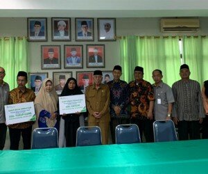 Kepala Kantor BPJS Ketenagakerjaan Bekasi Cikarang Achmad Fatoni menyerahkan santunan Jaminan Kematian pada ahli waris peserta anggota MUI Bekasi.(ist)