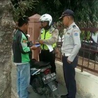 Petugas gabungan Sudishub Jakbar menilang tiga pengendara motor yang mangkal di trotoar di depan RS Soeharto Heerdjan di Jln Latumeten Raya, Grogol Petamburan. (Rachmi)