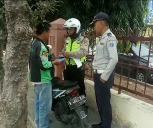 Petugas gabungan Sudishub Jakbar menilang tiga pengendara motor yang mangkal di trotoar di depan RS Soeharto Heerdjan di Jln Latumeten Raya, Grogol Petamburan. (Rachmi)