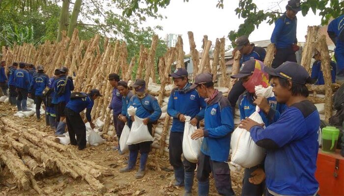 Petugas sedang melakukan pembuatan tanggul dari karung dan bambu. (wandi)