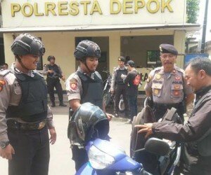 Kasat Sabara Polrestro Depok Kompol Subandi bersama anggota lengkap body face dan senjata laras panjang memeriksa tamu yang membuat laporan dengan mengecek tas gembok yang dibawa pos penjagaan. (angga)
