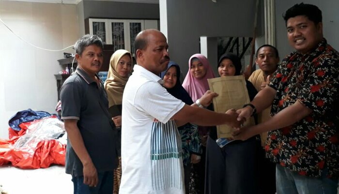 Manajemen provider tower seluler Iqbal saat menyerahkan bantuan dana perbaikan ke salah satu dari lima warga yang rumahnya rusak tertimpa tiang tower tersebut. (anton)