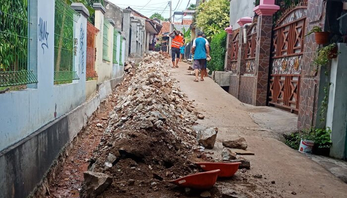 Tumpukan tanah pekerjaan saluran aor di Gang Kali Licin, Rangkapan Jaya yang dikeluhkan warfa dan pemakai kendaraan. (anton)