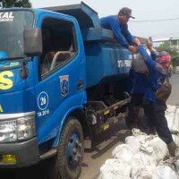 Sejumlah petugas sedang mengangkut karung berisi lumpur yang berada dari saluran air. (wandi)