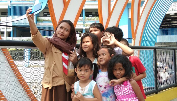 Anak-anak tengah berswafoto di atas jembatan ikonik berornamen ketupat di Jalan Sekolah, Kelurahan Petojo Utara. (ist)