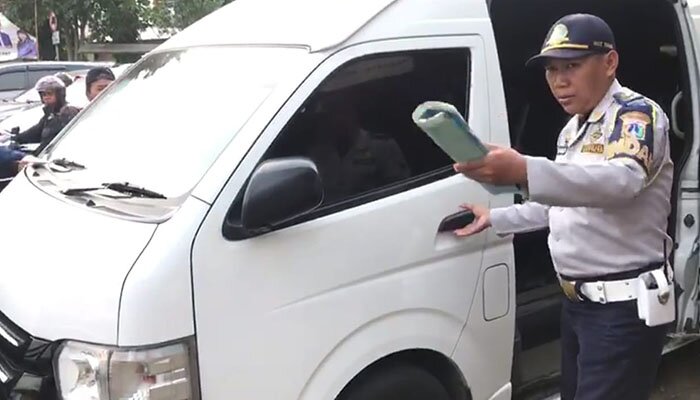 Petugas Sudishub Jakbar mencabut izin operasi 3 minibus yang mangkal di terminal bayangan di Meruya Utara, Kembangan. (Rachmi)