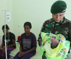 Anggota TNI bantu warga Papaua melahirkan.