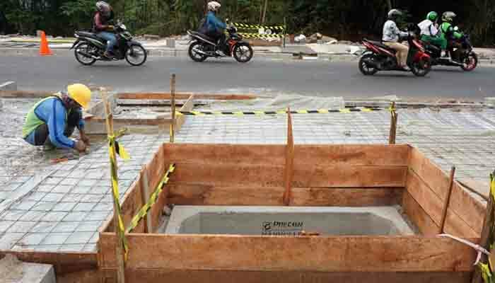 Pekerja melakukan pengerjaan proyek trotoar (toga)