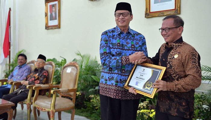 Gubernur Banten, Wahidin Halim saat menerima Anugerah Keterbukaan Informasi Badan Publik dari Ketua Komisi Informasi Pusat, Gede Narayana di Istana Wakil Presiden RI