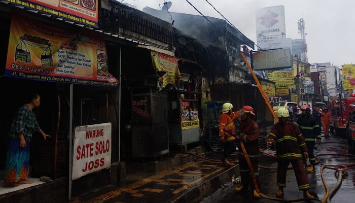 Sejumlah anggota Damkar Kota Depok tengah memadamkan api di empat kios Jalan Raya Margonda, Depok. (anton)