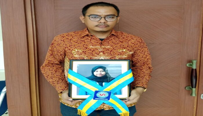 Andri memegang foto adiknya, almarhumah Riskiyani Septia. (ist)