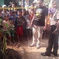Petugas satreskrim tengah melakukan evakuasi mayat bayi terselip diantara tanaman.