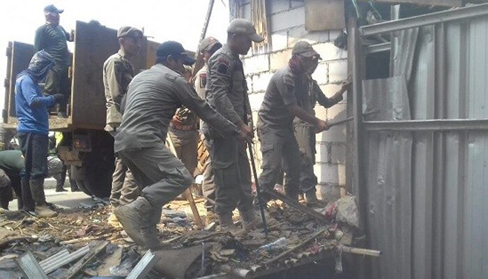 Sejumlah anggota Satpol PP Depok saat membongkar bangunan liar di atas saluran air Pasar Kemiri Muka, Beji. (anton)