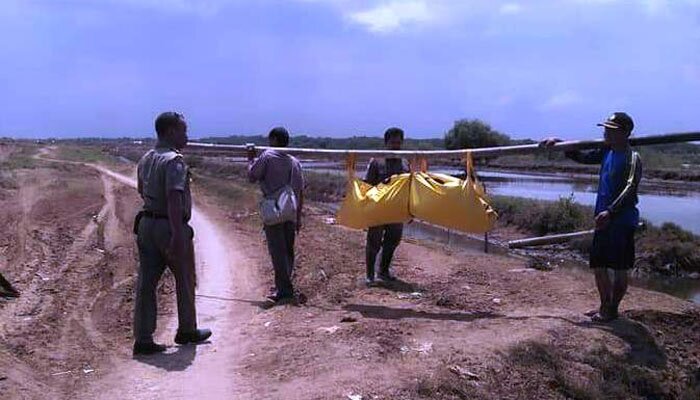 Petugas memikul kantong jenazah tanpa identitas dari muara Sungai Rambatan di Blok Waledan, Desa Lamarantarung, Kecamatan Cantigi, Indramayu, Jawa Barat, Selasa, (24/12/2019). (taryani)
