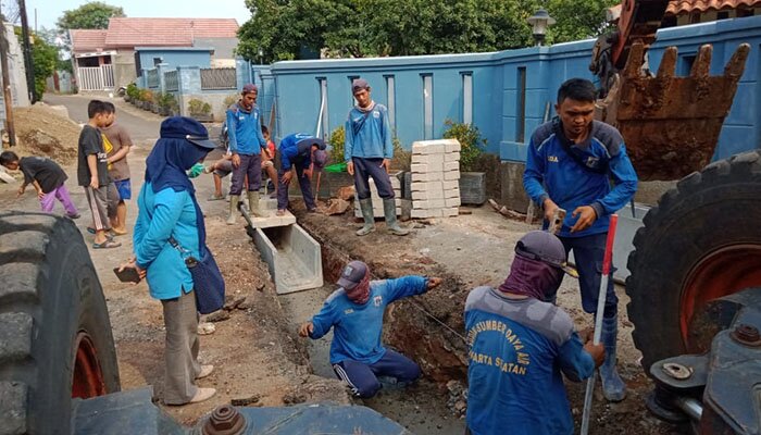 Petugas sedang membuat saluran air disepanjang Jalan Nila, Ciganjur. (wandi)