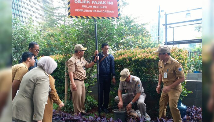 Walikota Jaksel saat melakukan pemasangan plat penunggak pajak di hotel The Grove Suites. (wandi)