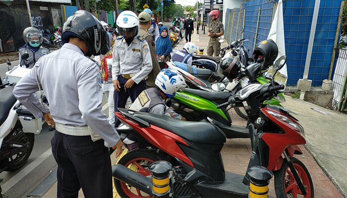 Petugas sedang menindak kendaraan yang parkir sembarangan. (wandi)
