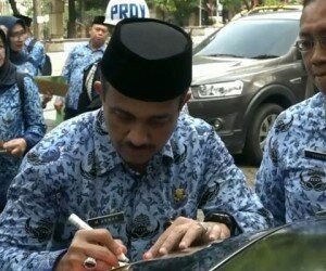 Walikota Jaktim saat menempel stiker penunggak pajak di mobil milik ASN. (Ifand)