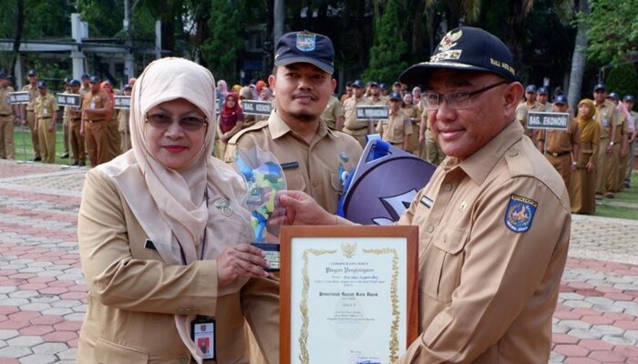 Wali Kota Depok Muhammad Idris saat menyerahkan penghargaan rakuat dan pasar kecil dari Propinsi Jabar kepada Kadisdagin Kania Parwati. (anton)