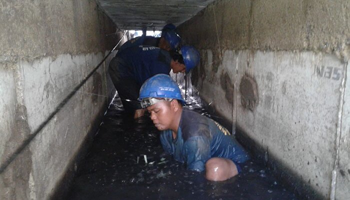Pasukan biru Sudis SDA Jakbar nyemplung ke saluran untuk menguras endapan lumpur di kawasan Grogol Petamburan. (rachmi)