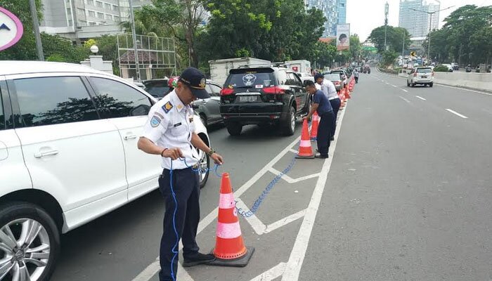 Petugas sedang melakukan pemesangan pembatas jalan di JLNT Casablangka. (wandi)