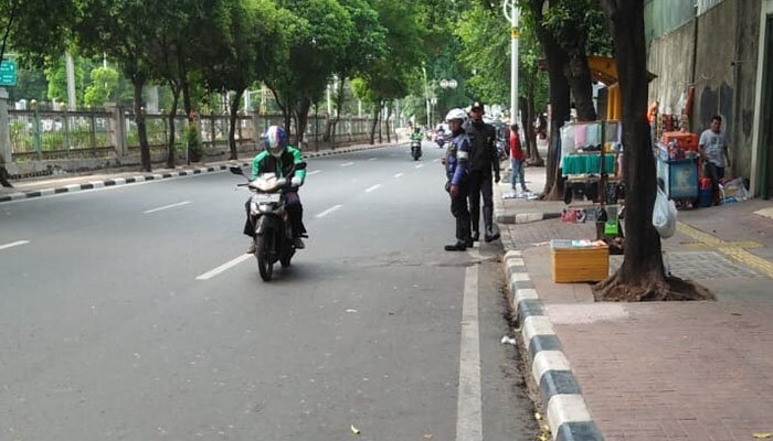 Petugas Sudishub Jakbar menertibkan pengemudi ojol yang mangkal di trotoar dan bahu jalan di depan Stasiun Palmerah, Kecamatan Palmerah. (rachmi)