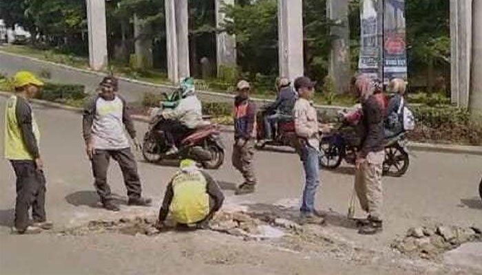 Sejumlah anggota Satgas DPUPR Kota Depok tengah memperbaiki kerusakan atau menambal badan jalan yang berlubang di kawasan Jl. Raya GDC Sukmajaya. (anton)