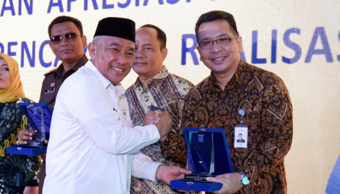 Wali Kota Depok Muhammad Idris saat menyerahkan penghargaan ke Kepala BJB Depok Ade. (anton)