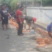 Warga Tugu Selatan, Koja, memperbaiki jalan rusak dengan hasil urunan. (deny)